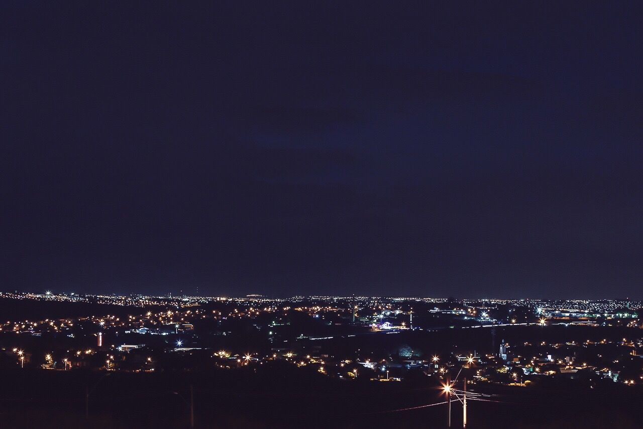 VIEW OF ILLUMINATED CITYSCAPE AT NIGHT