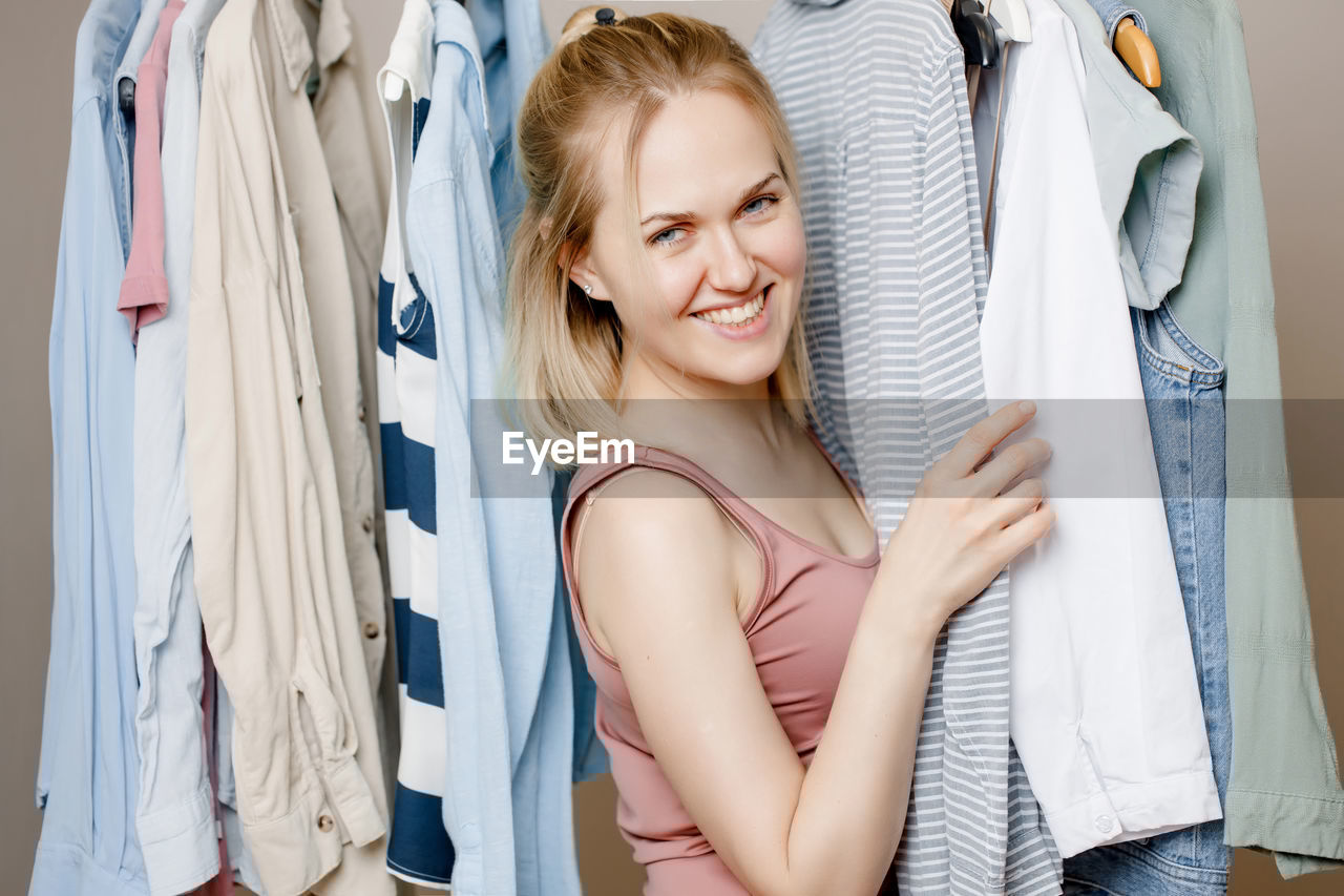 portrait of smiling young woman sitting on bed at home