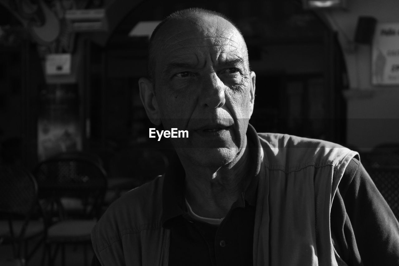 Bald man looking away in darkroom