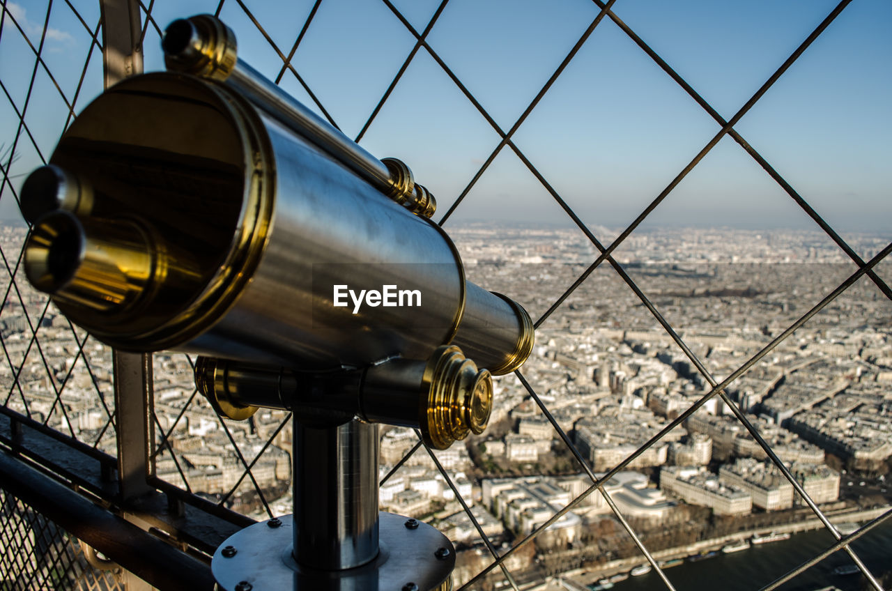 Close-up of coin-operated binoculars against cityscape