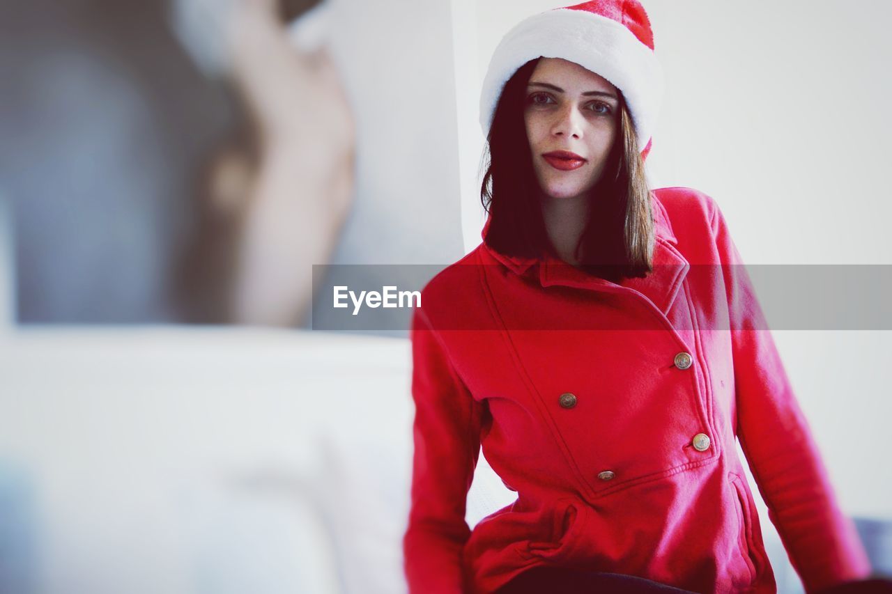 Portrait of young woman wearing santa hat at home