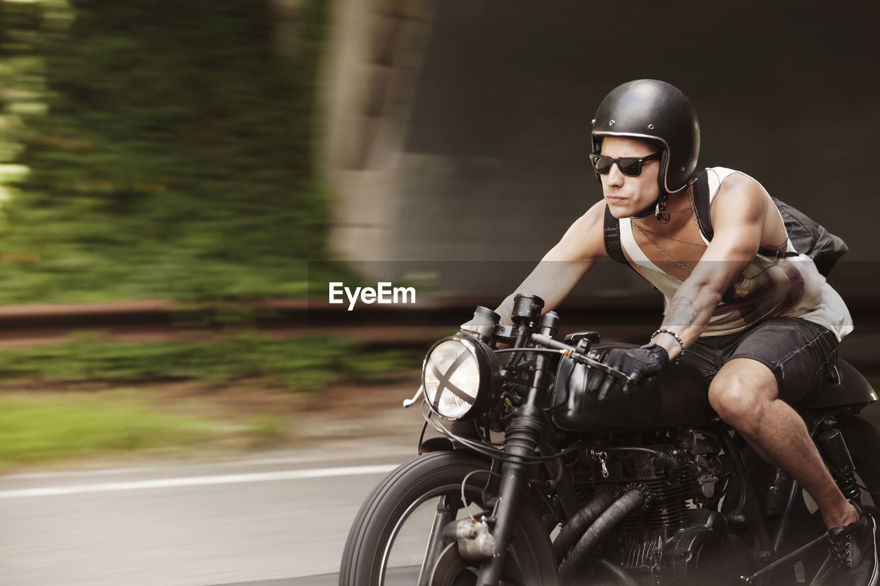 Confident man riding motorcycle on road