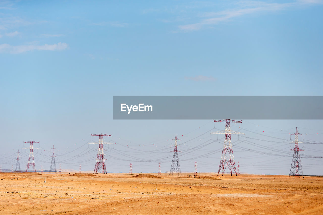 ELECTRICITY PYLONS ON LAND AGAINST SKY