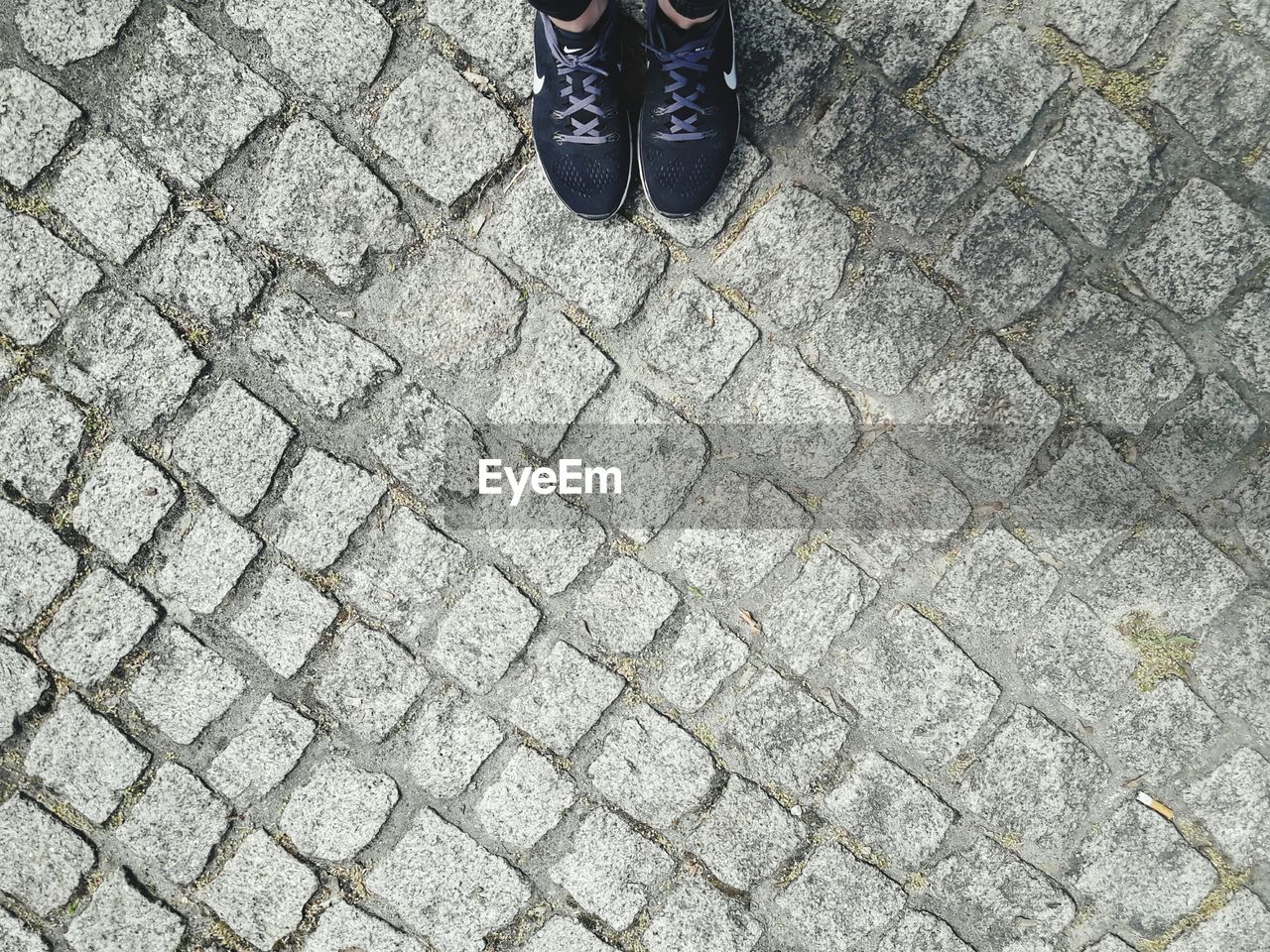 LOW SECTION OF MAN STANDING ON PAVING STONE