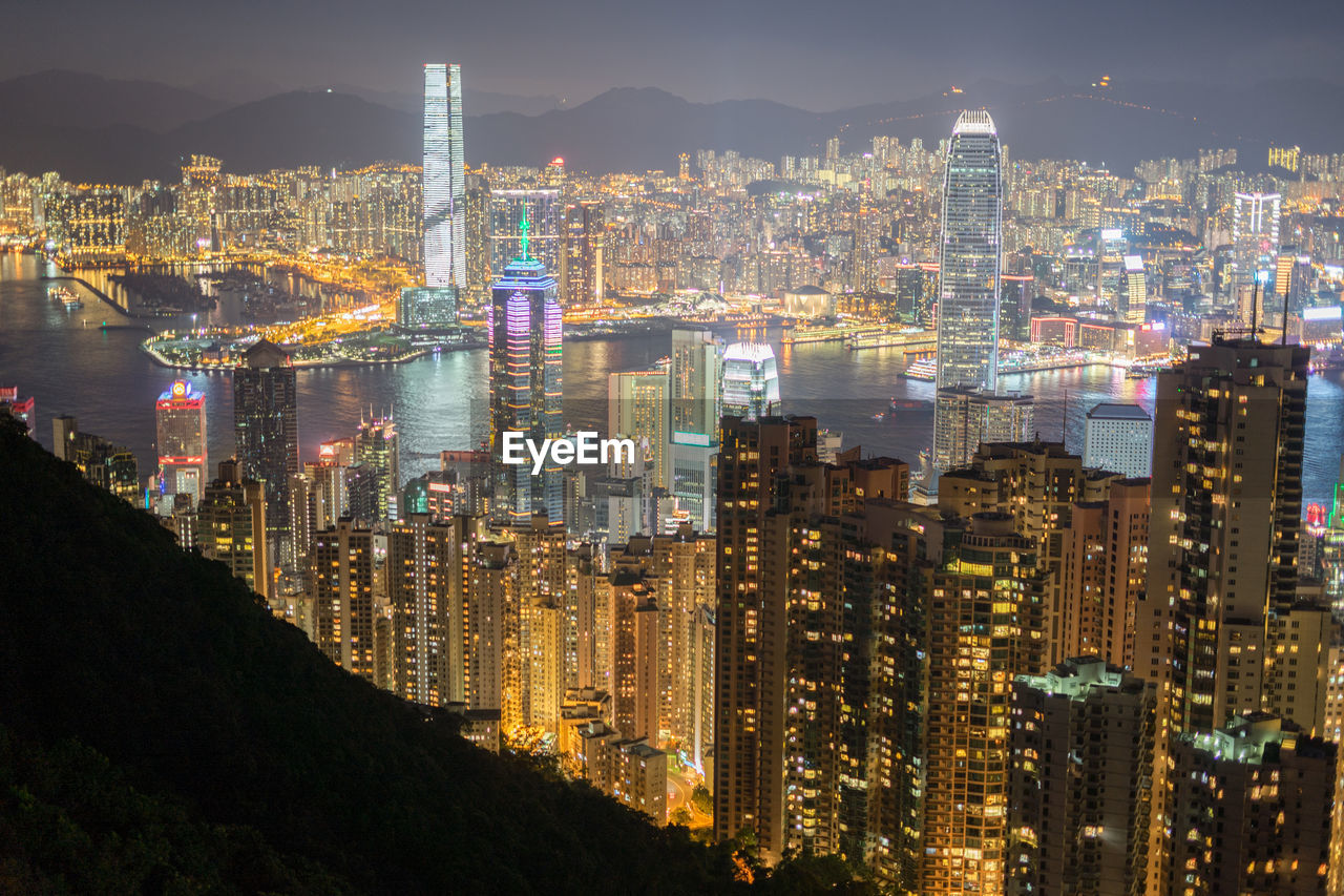 HIGH ANGLE VIEW OF ILLUMINATED CITY BUILDINGS AGAINST SKY