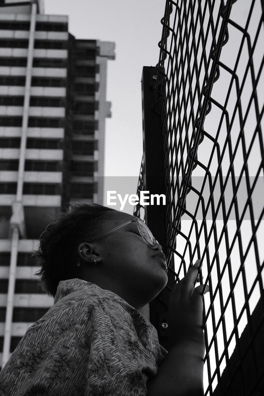 Low angle view of woman looking at modern buildings in city