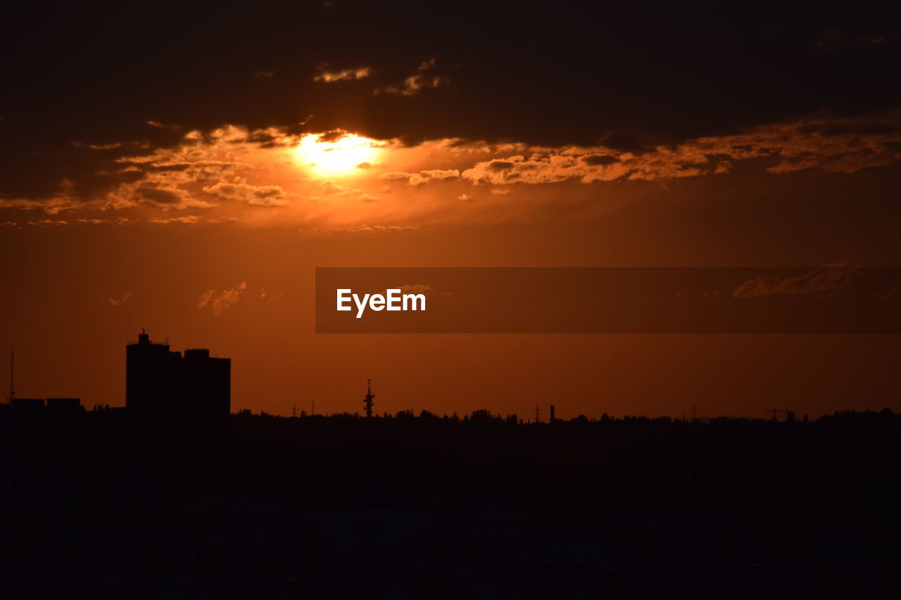 Silhouette cityscape against sky during sunset