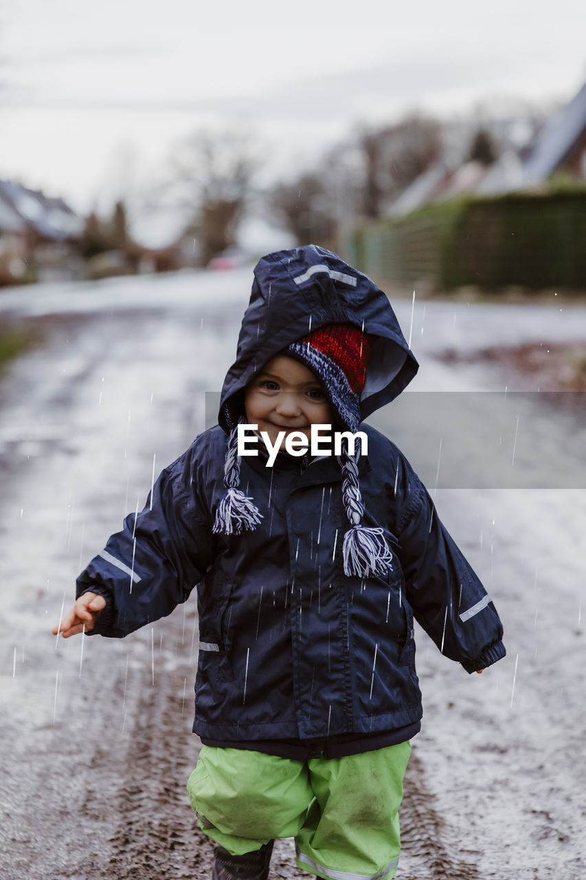 Baby girl standing on road during winter