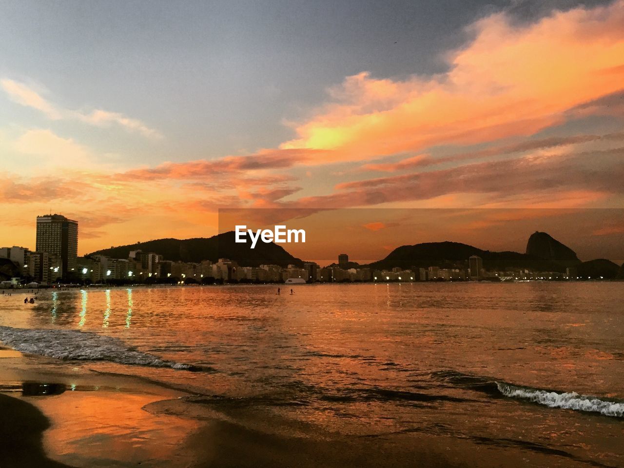 Scenic view of beach against cloudy sky