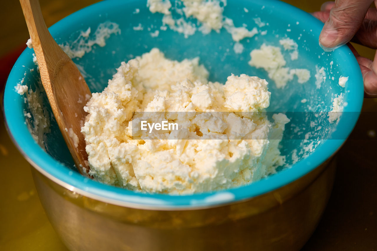 HIGH ANGLE VIEW OF PERSON PREPARING FOOD IN CONTAINER