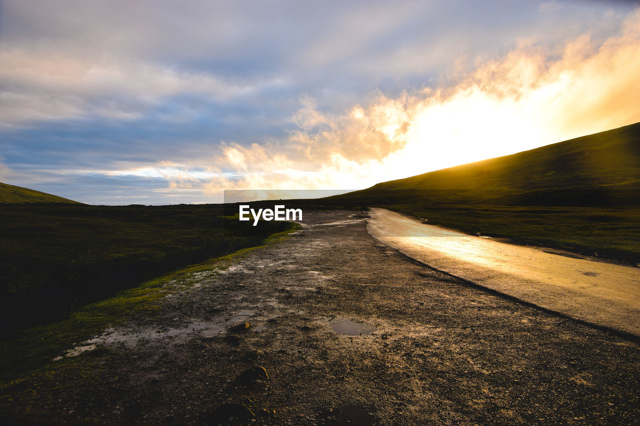 Road amidst landscape against sky during sunset