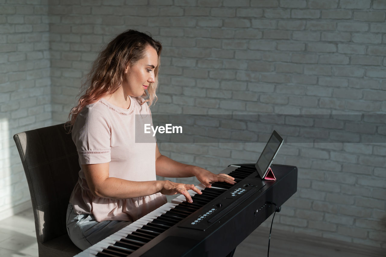 side view of woman using laptop while sitting at home