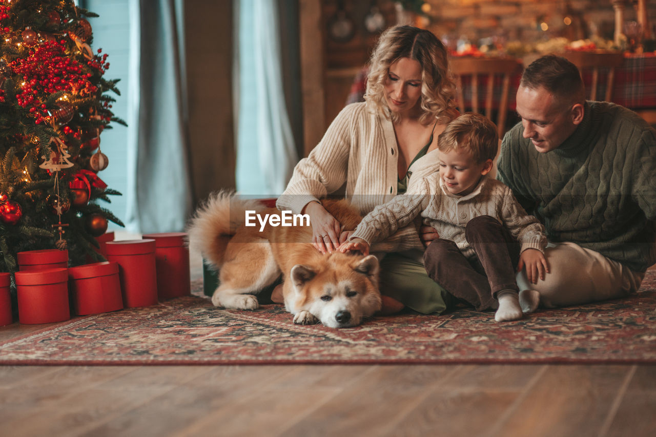 Candid authentic happy family during wintertime together enjoying holidays with dog at xmas