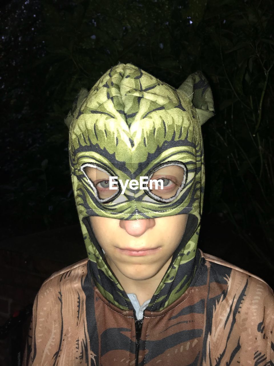 Close-up portrait of boy wearing mask at night