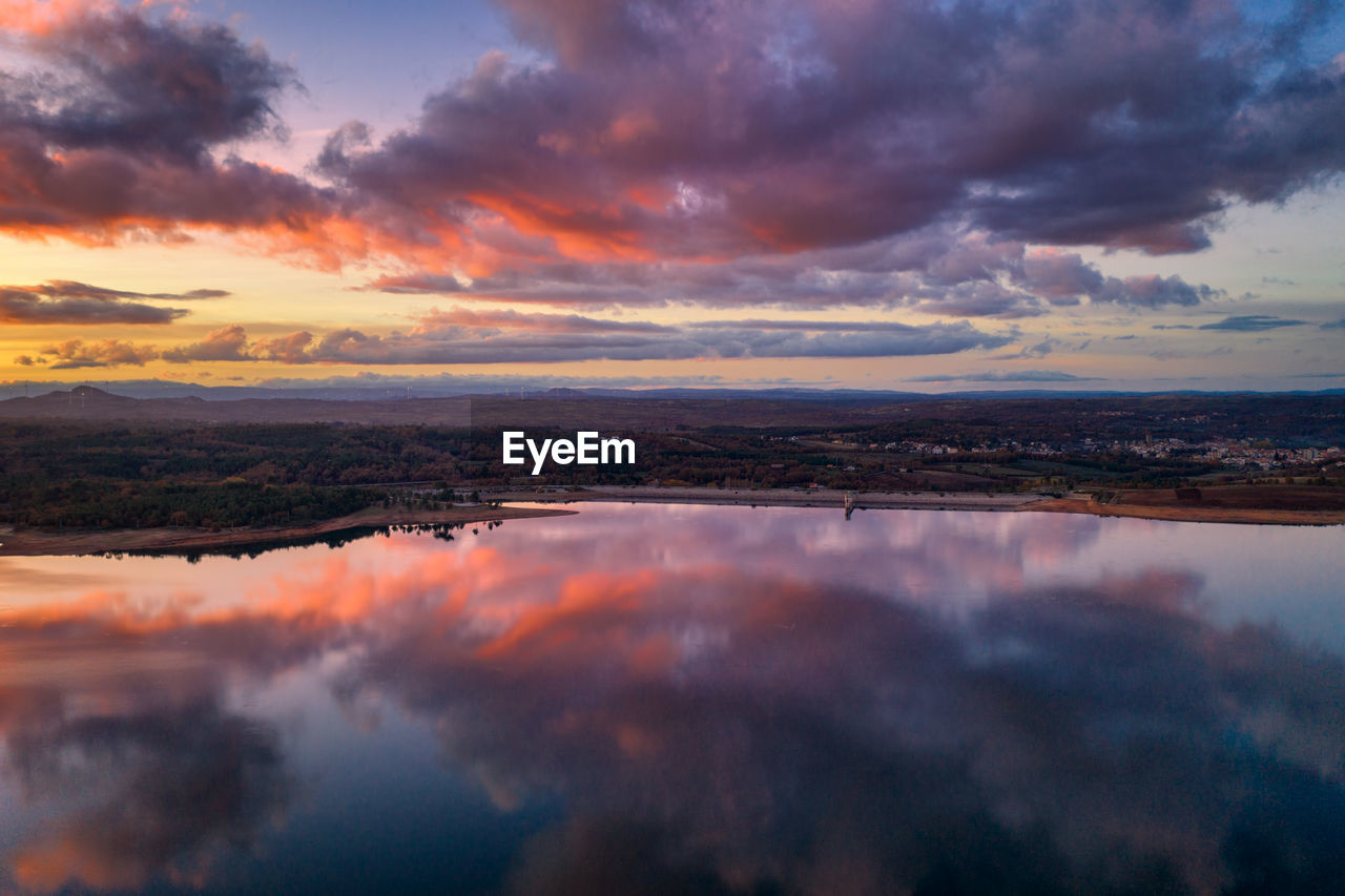 Drone aerial view of a lake reservoir of a dam with reflection on the water in sabugal, portugal