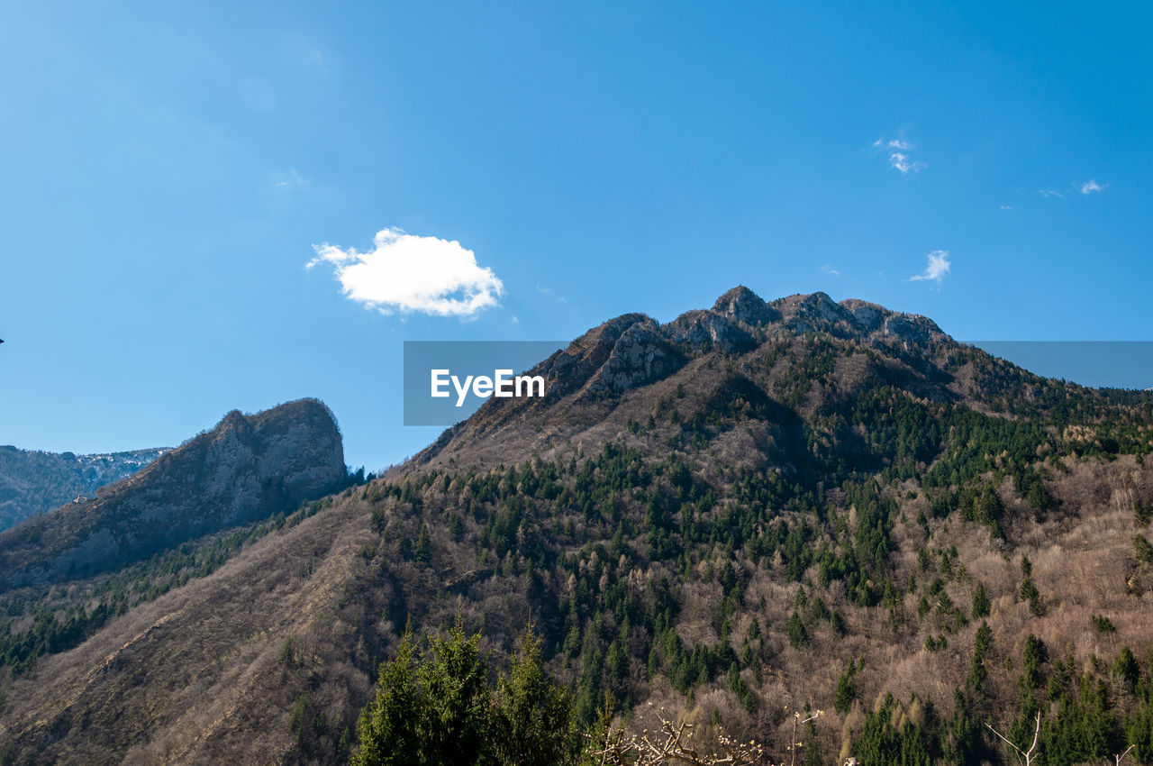 LOW ANGLE VIEW OF MOUNTAIN RANGE AGAINST BLUE SKY