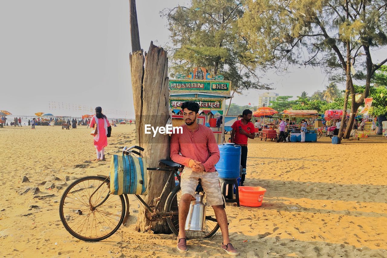 Man sitting on bicycle at beach