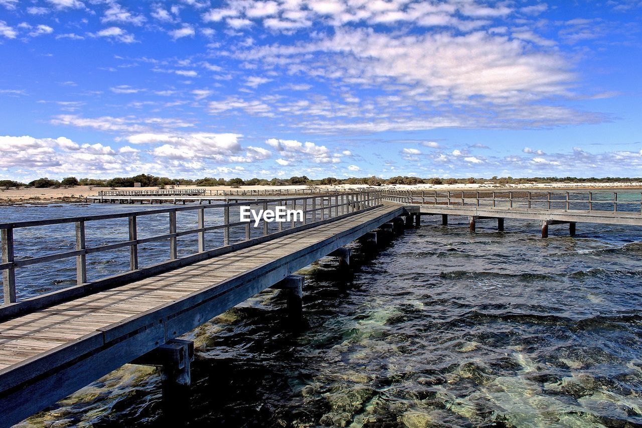 Pier over bay against sky