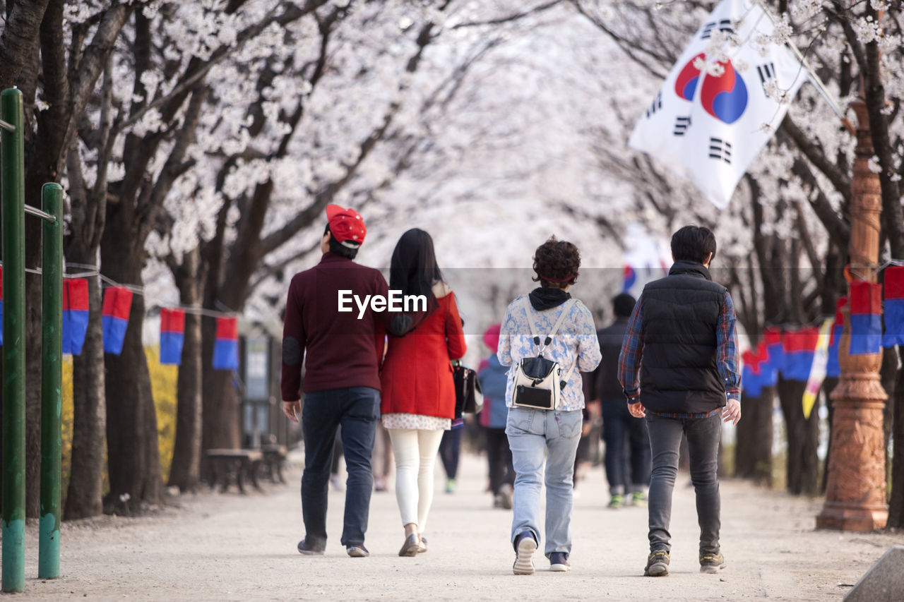 Rear view of people walking on footpath amidst cheongsachorongs