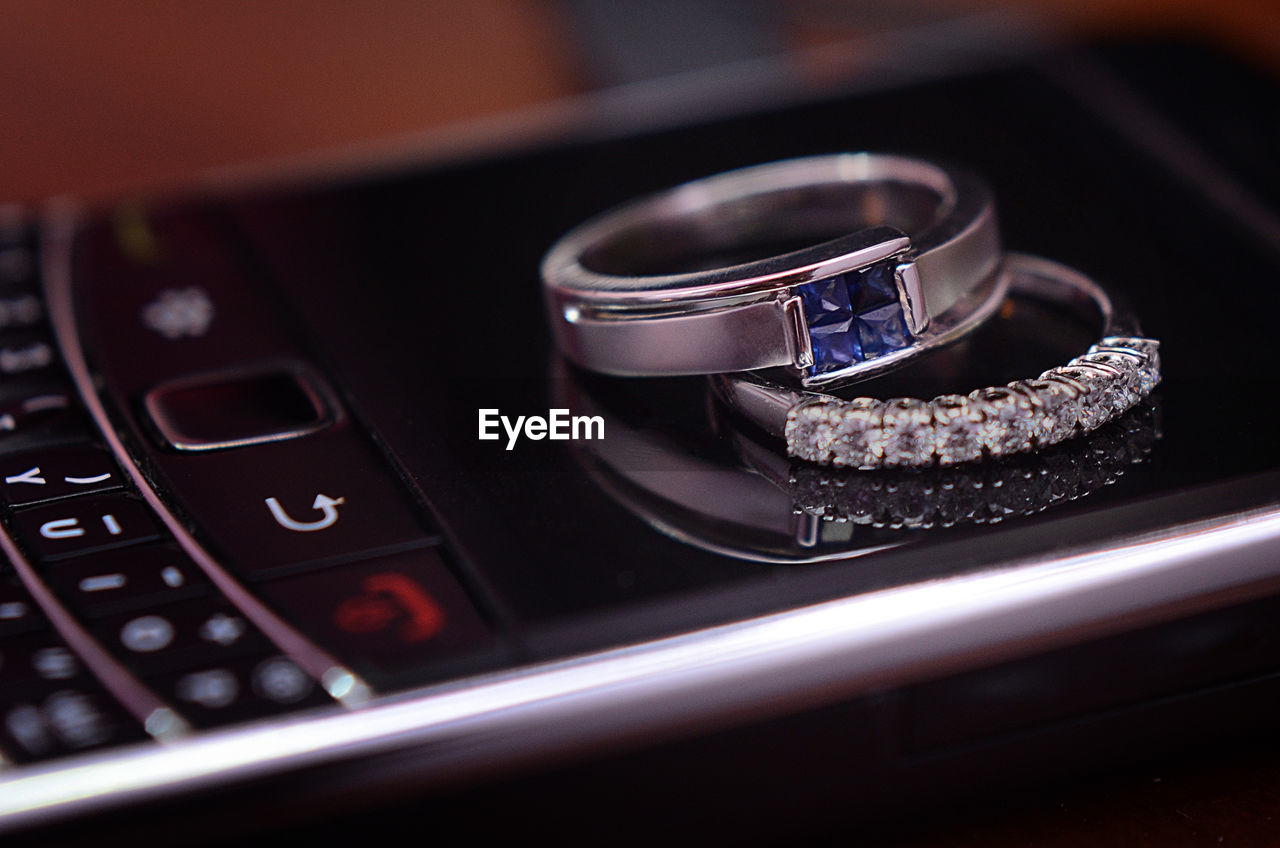 Close-up of wedding rings on cellphone