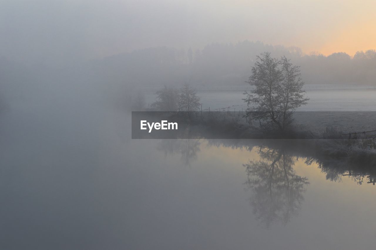 Scenic view of lake against sky during winter