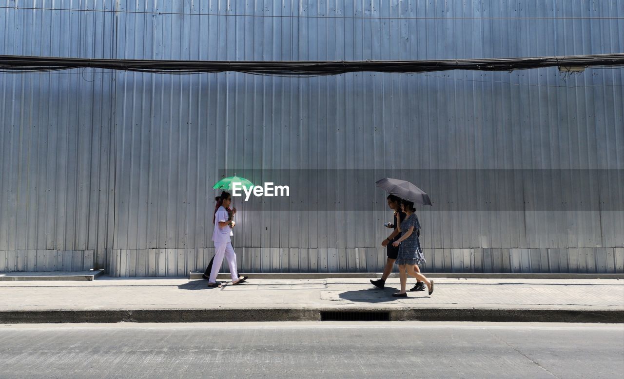 SIDE VIEW OF A MAN STANDING AGAINST CITY