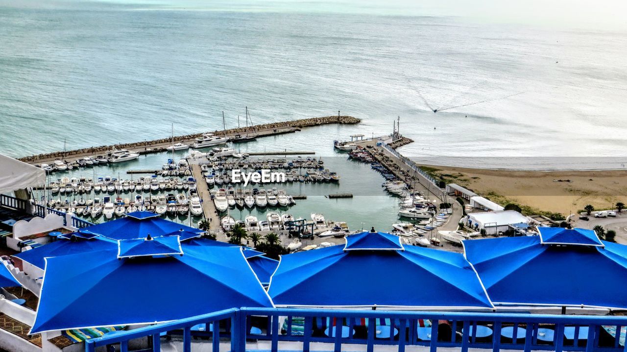 HIGH ANGLE VIEW OF BEACH UMBRELLAS ON SEA