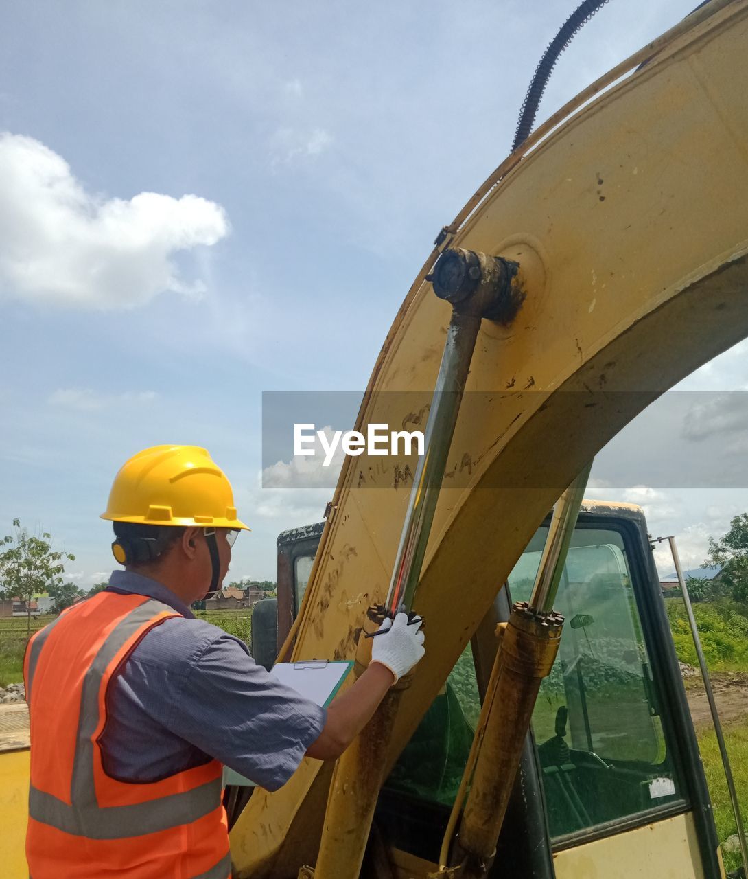 LOW ANGLE VIEW OF MAN WORKING ON YELLOW