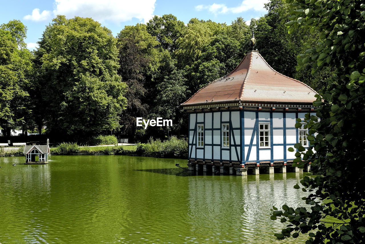 Gazebo by lake against sky