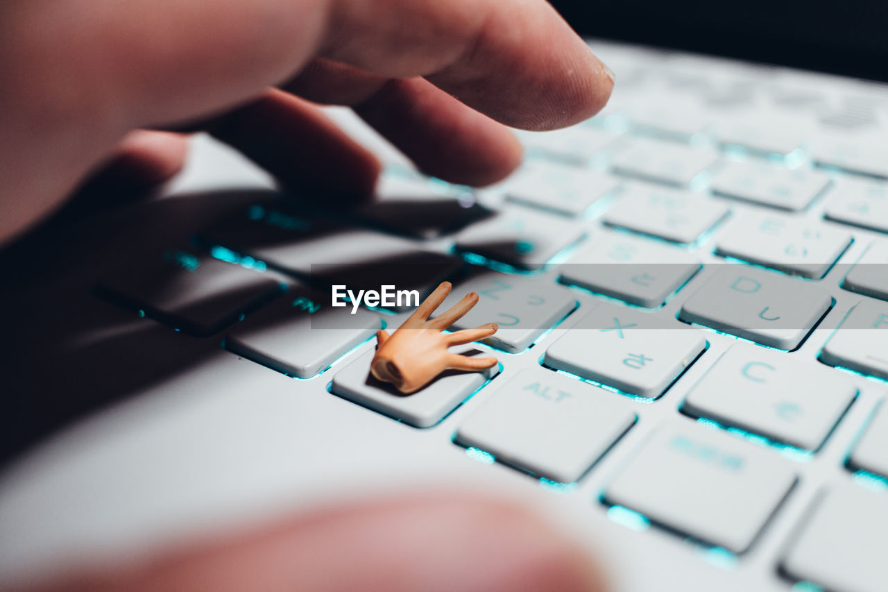 Close-up of person using keyboard but small hand on the key