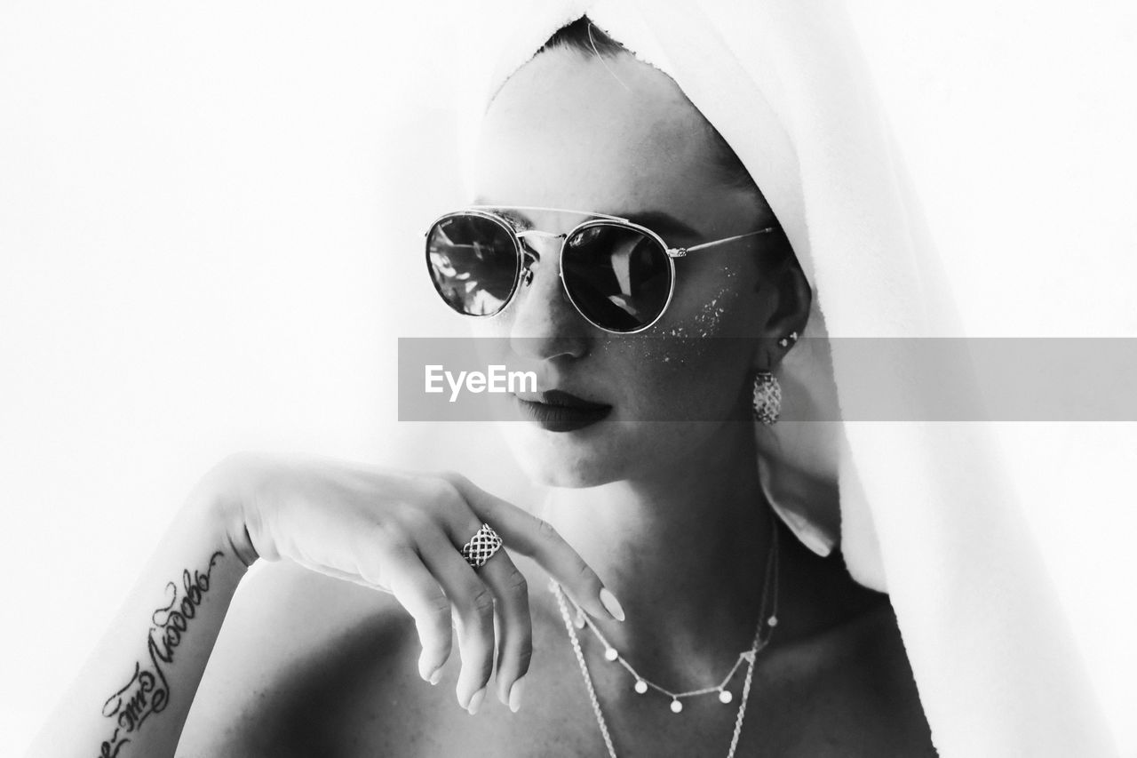 Portrait of young woman wearing sunglasses looking away