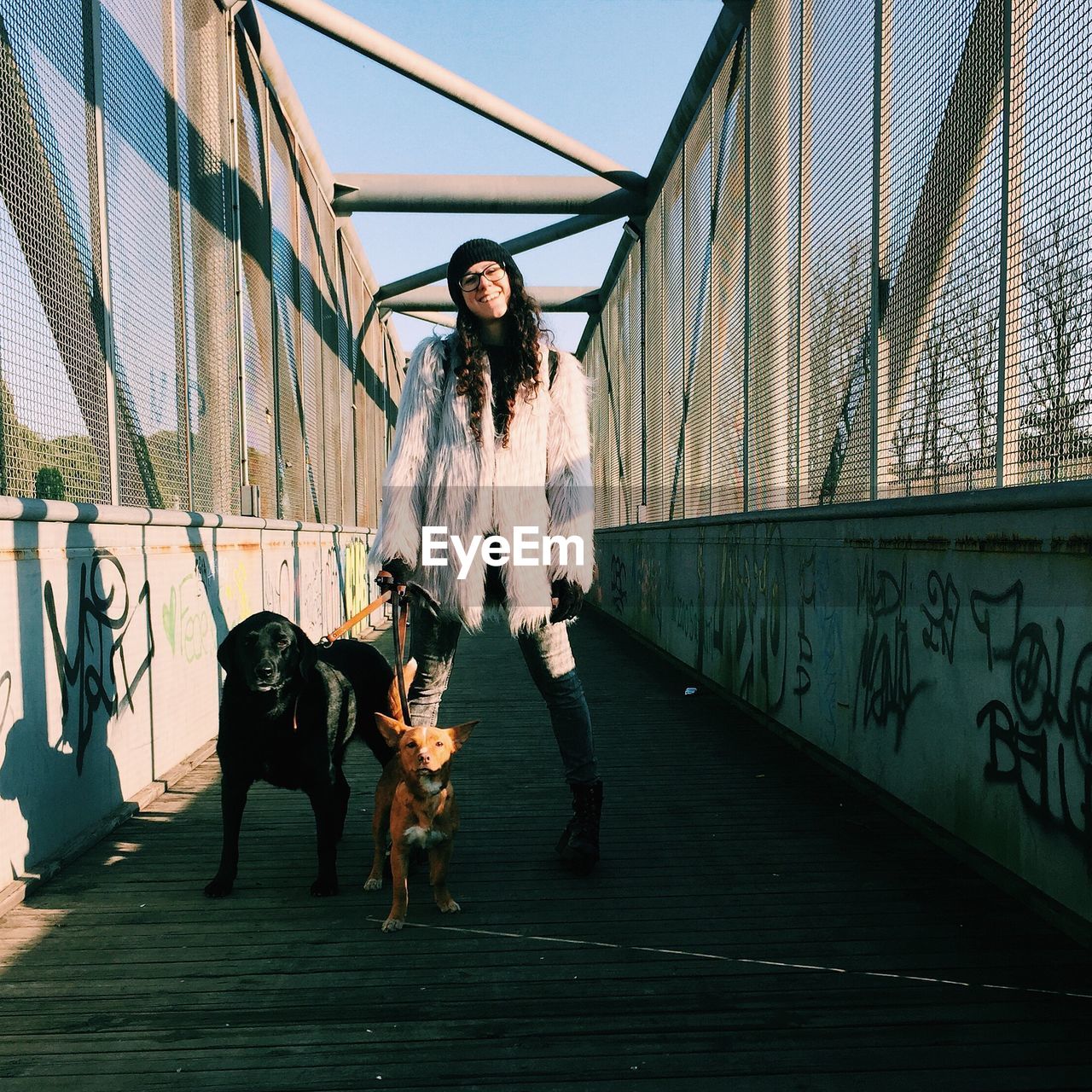 Woman standing on footbridge with dog