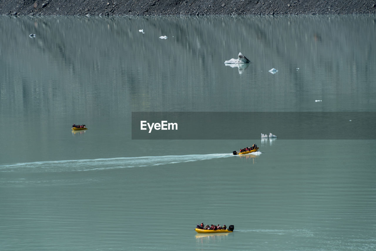 High angle view of people sailing boat in lake at tasman glacier