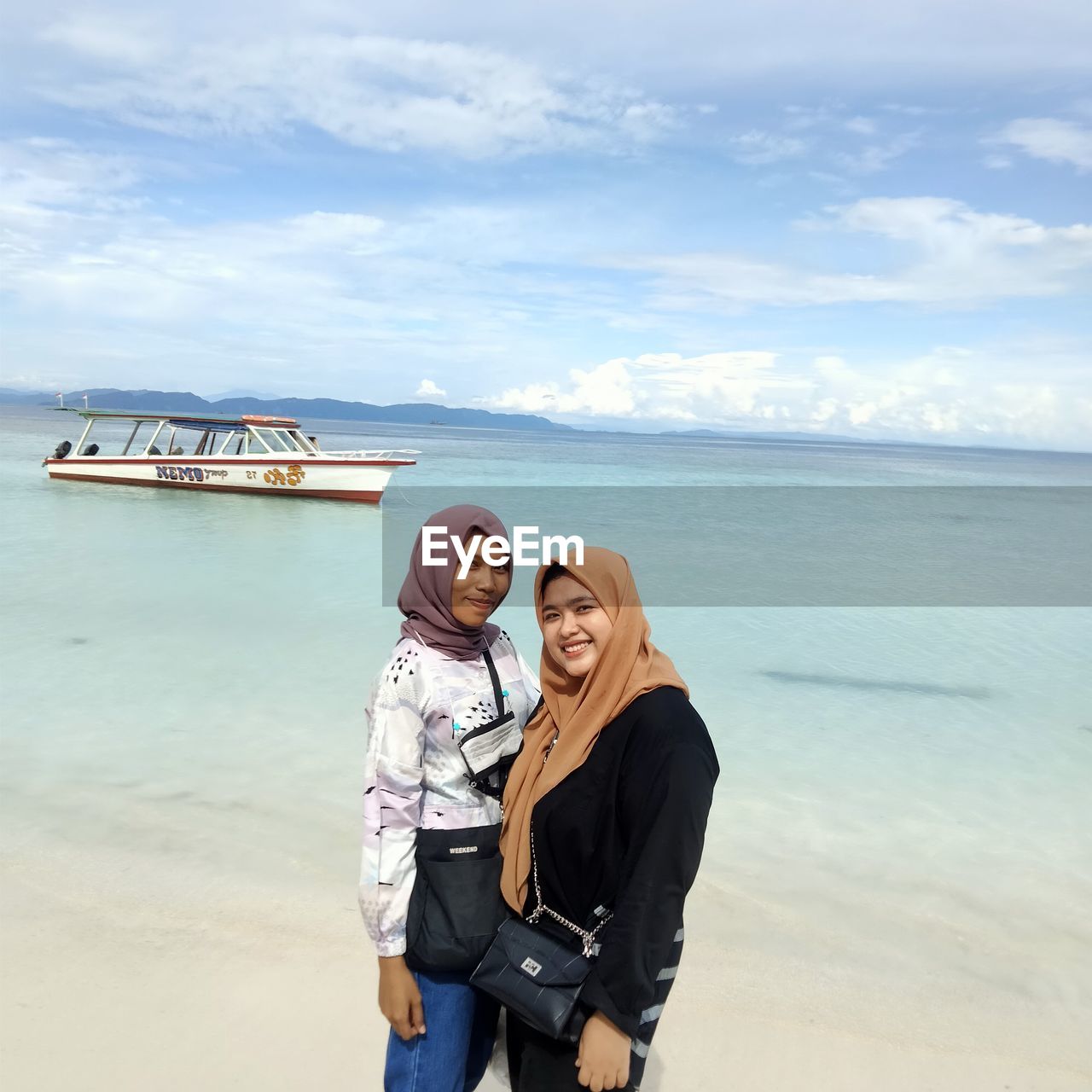 PORTRAIT OF BEAUTIFUL WOMAN STANDING AGAINST SEA