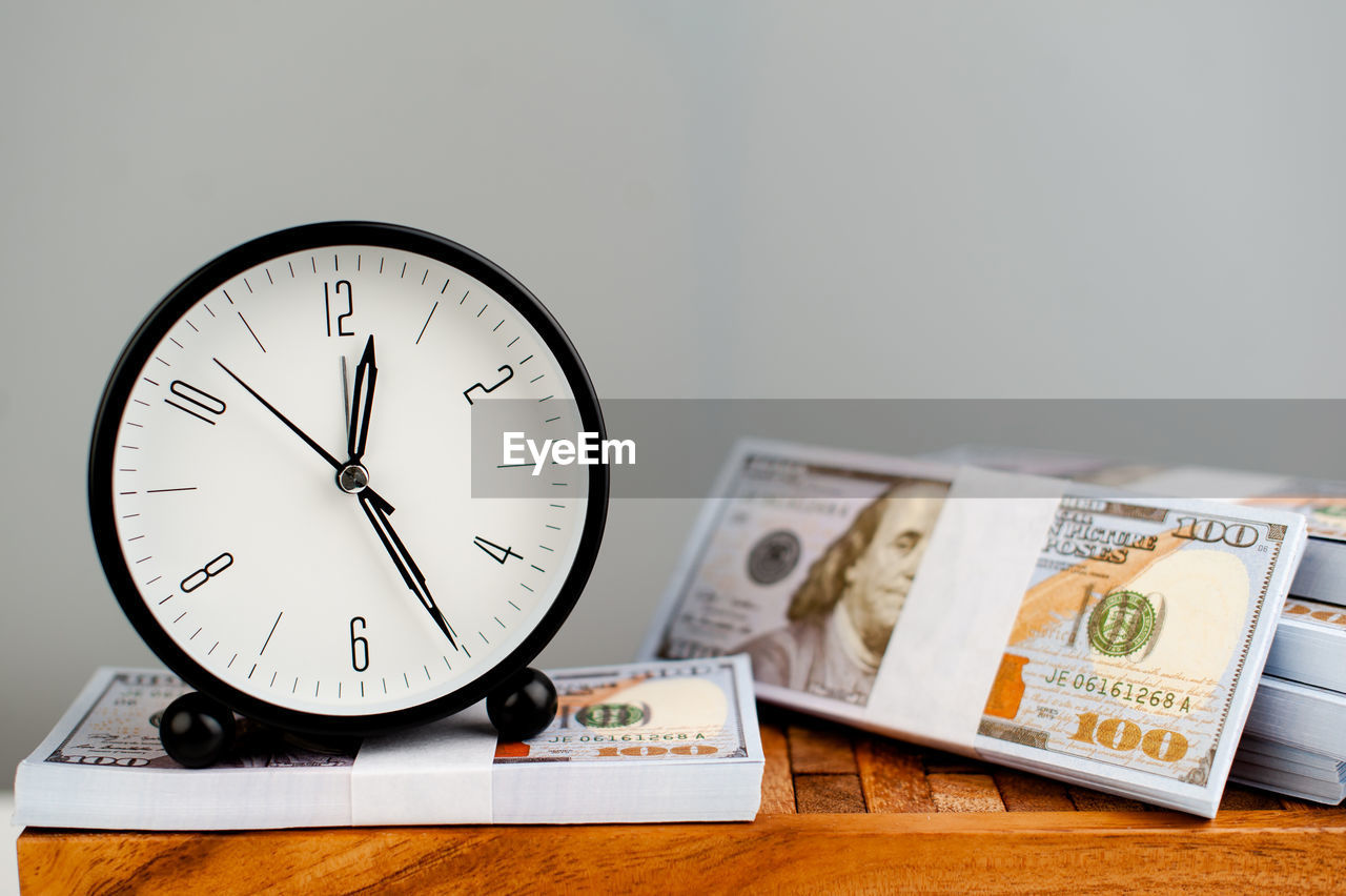 clock, time, business, indoors, finance, number, studio shot, currency, paper currency, wealth, no people, table, money, copy space, still life, cash, deadline, close-up