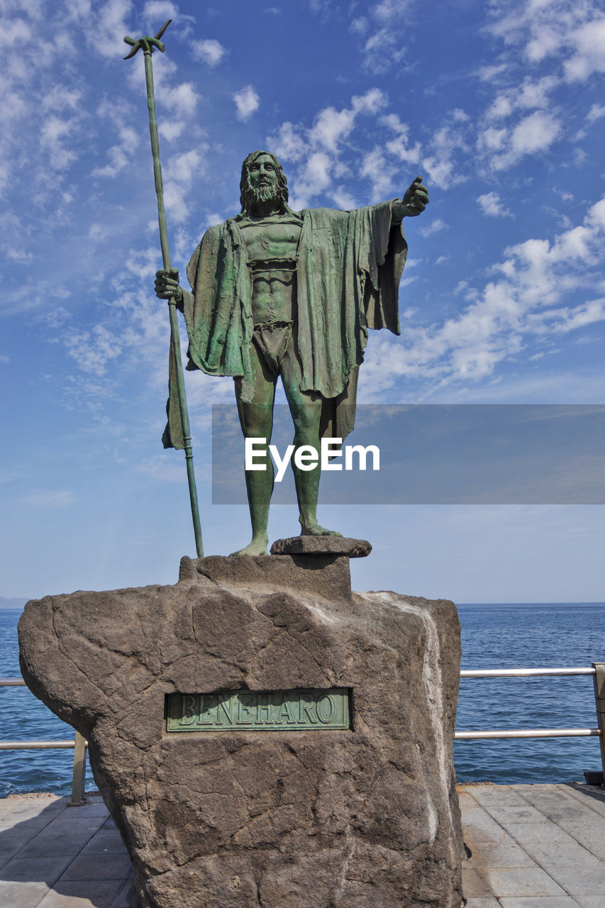 sky, sculpture, water, statue, nature, sea, human representation, cloud, representation, craft, travel destinations, day, monument, architecture, no people, vacation, male likeness, blue, travel, history, the past, outdoors, art, memorial, beach, tourism, horizon over water