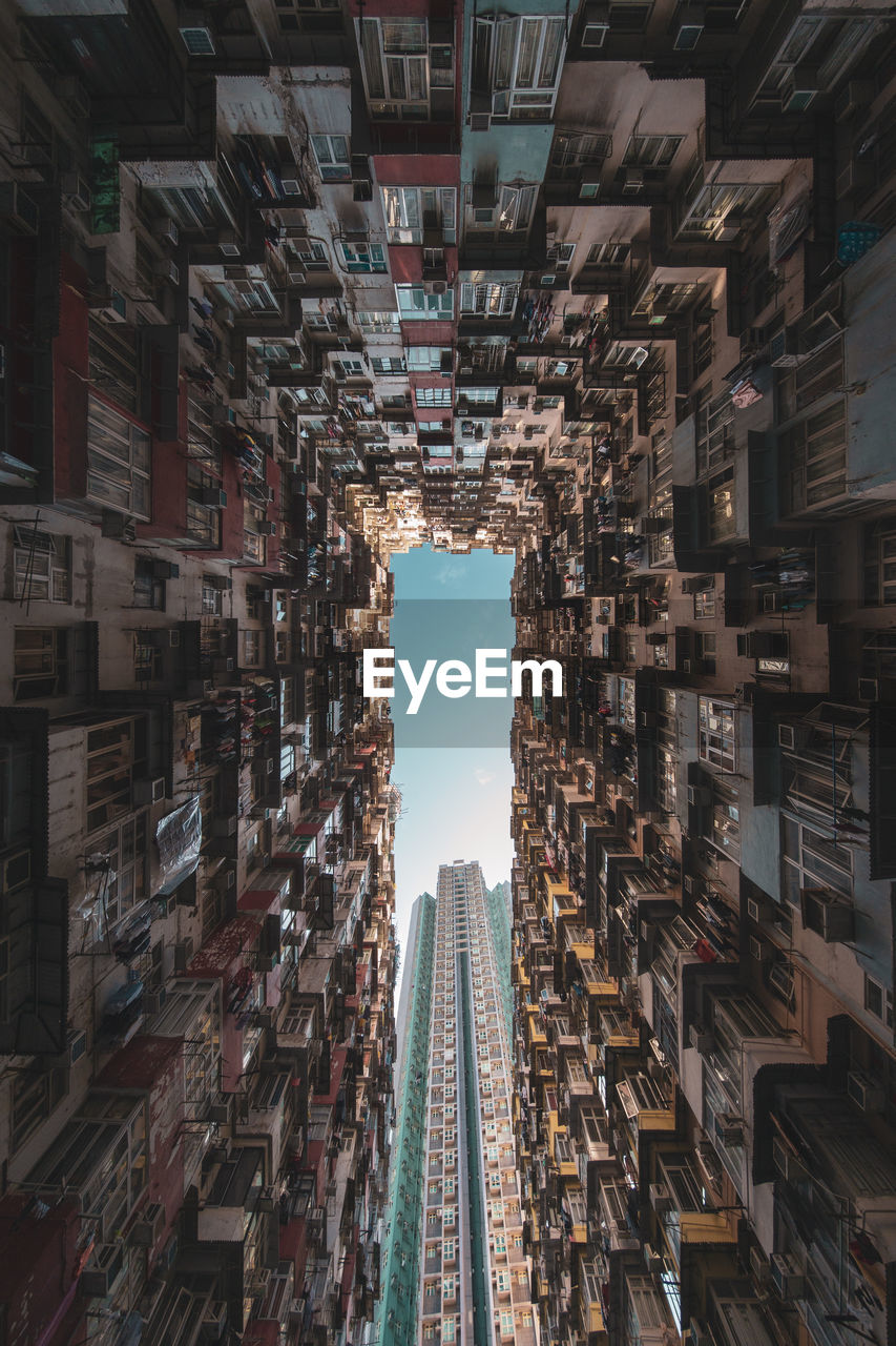 Directly below shot of buildings in city against sky