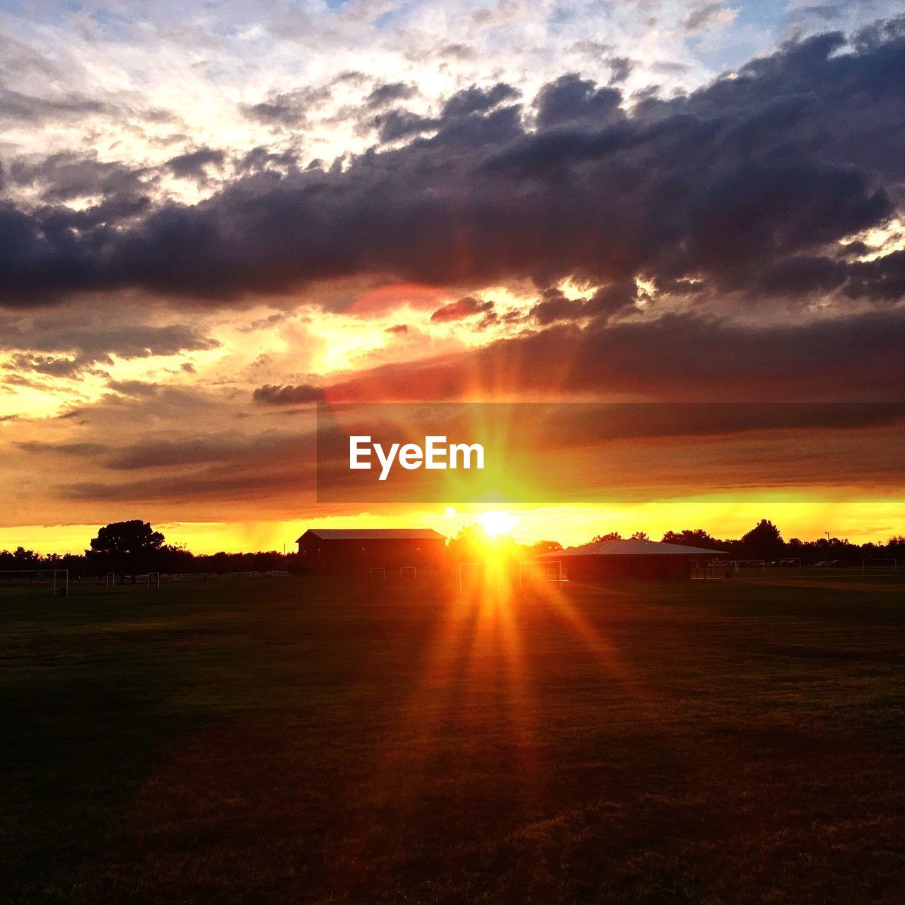 Scenic view of silhouette field against orange sky