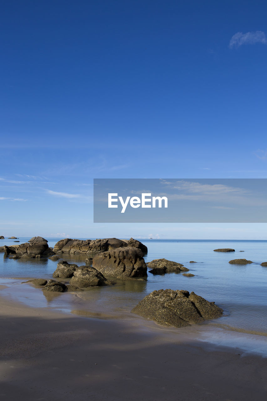 Scenic view of beach against blue sky