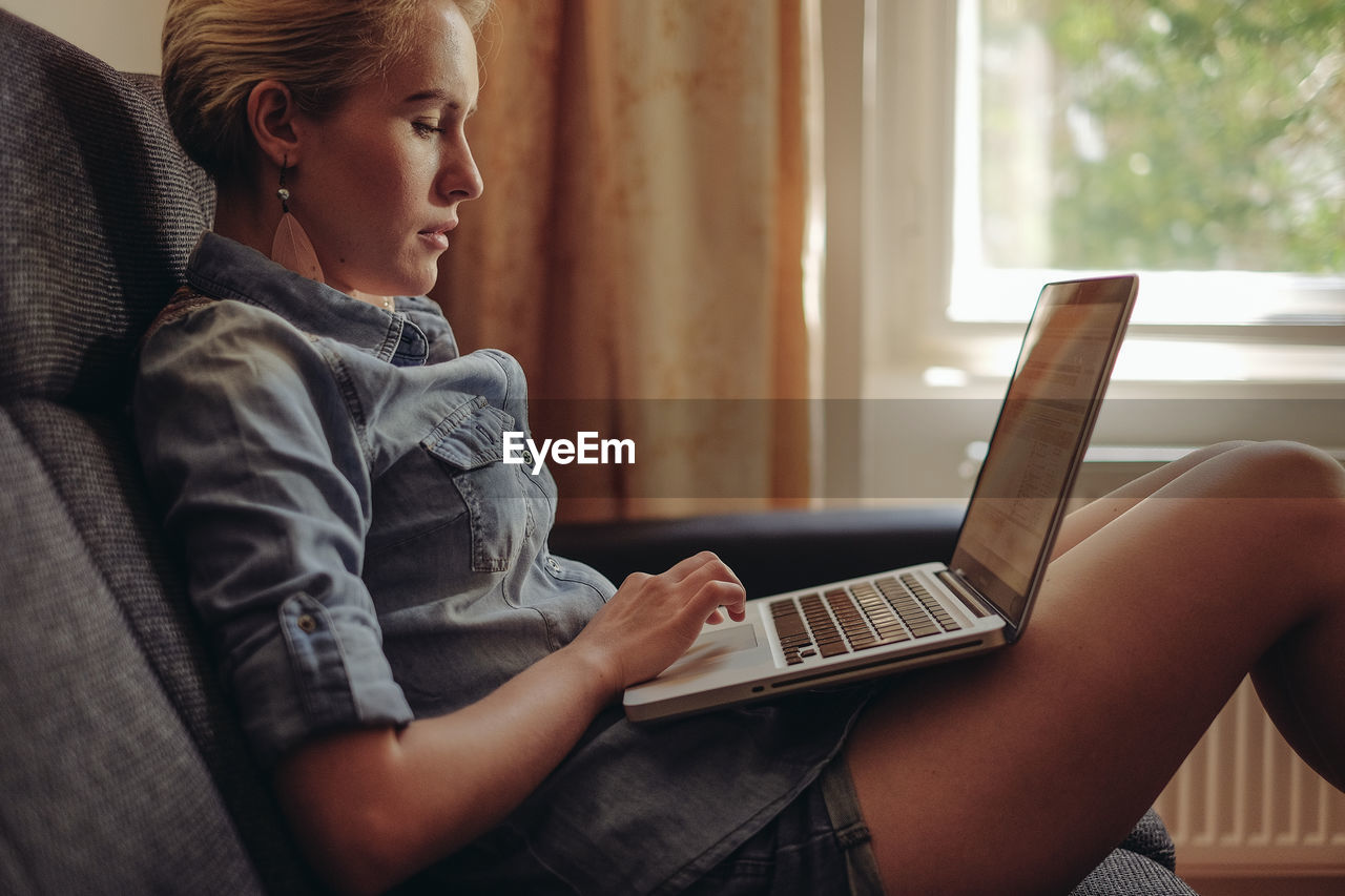 Side view of woman using laptop