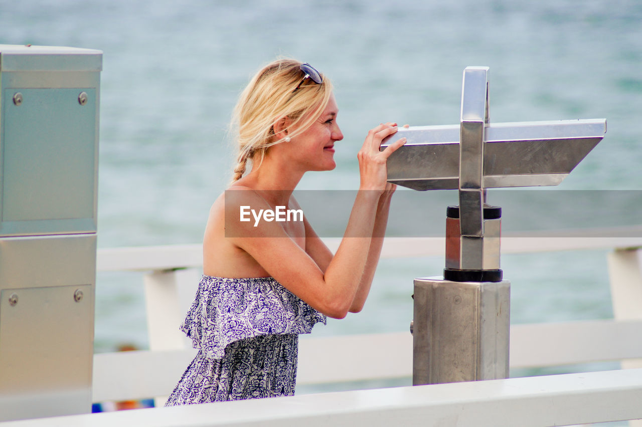 Young woman holding binoculars at observation point