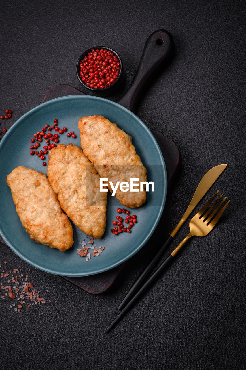 food and drink, food, studio shot, no people, dish, healthy eating, freshness, plate, indoors, kitchen utensil, high angle view, black background, fruit, produce, meal, directly above, eating utensil, fast food, fried, baked, fork, wellbeing, breakfast, fish, gray