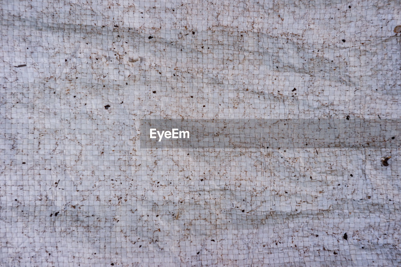 FULL FRAME SHOT OF WEATHERED WOOD ON TEXTURED SURFACE