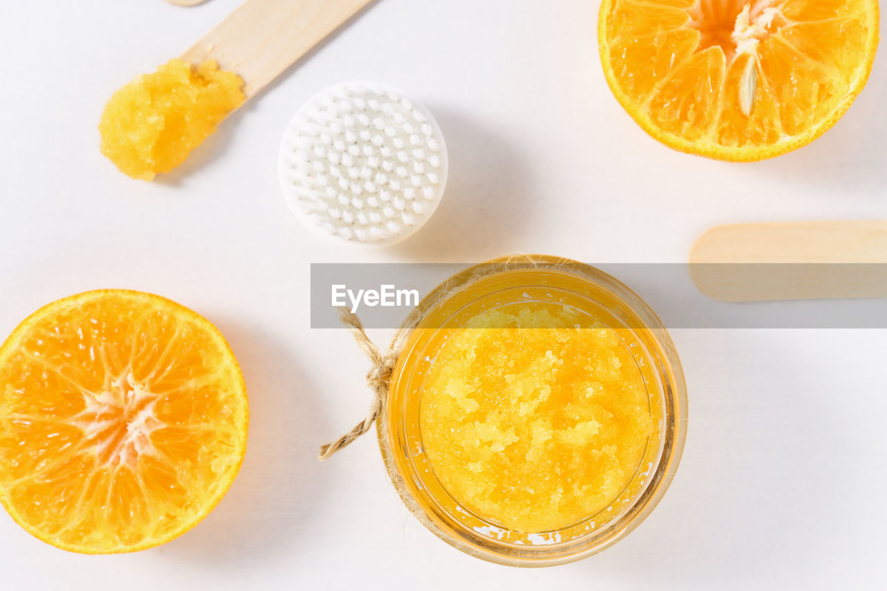 Sugar scrub with orange pieces on a white background, top view. beauty procedures for peeling 