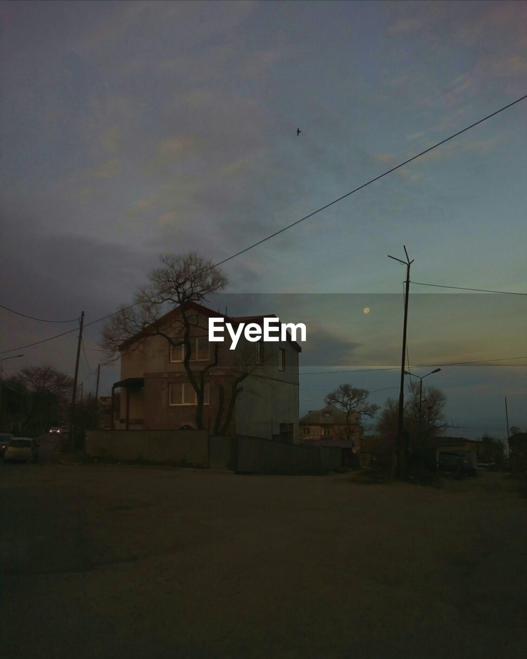 HOUSES AND TREES AGAINST SKY AT DUSK