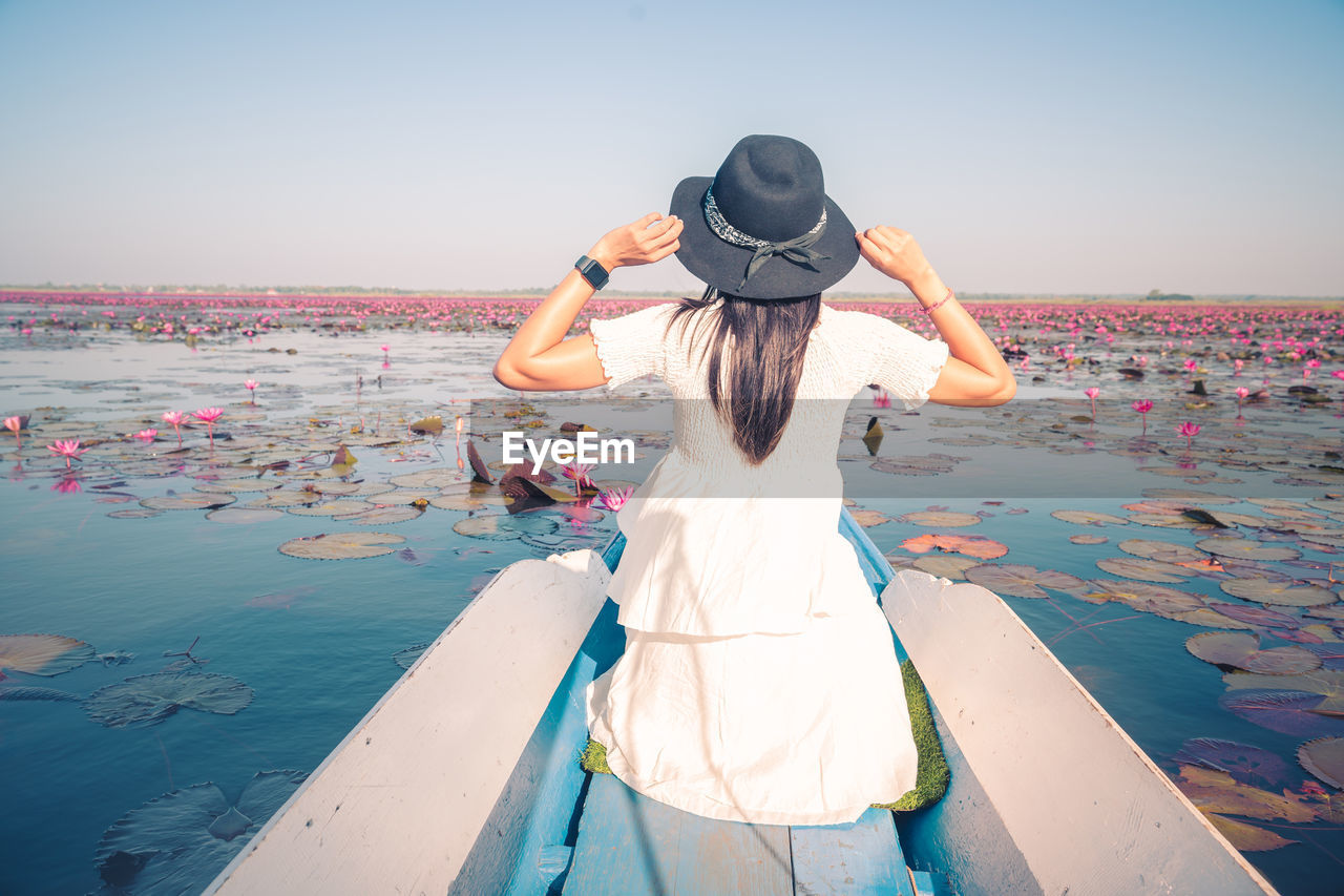 Asian tourist woman on a blue long tail boat at amazing red lotus sea. unseen in thailand.