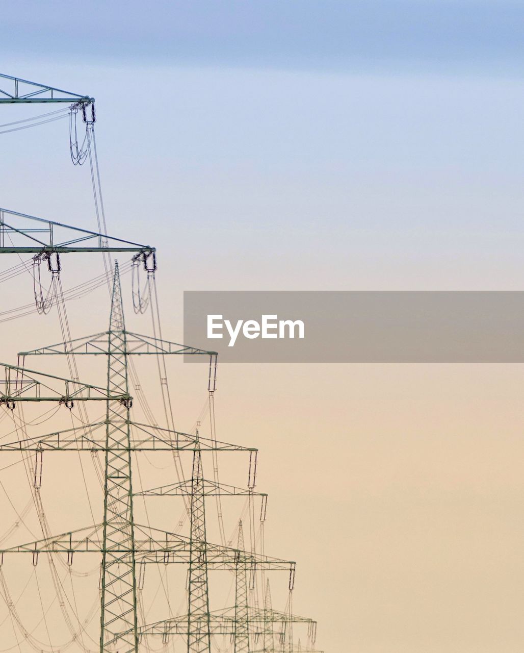 low angle view of electricity pylons against sky