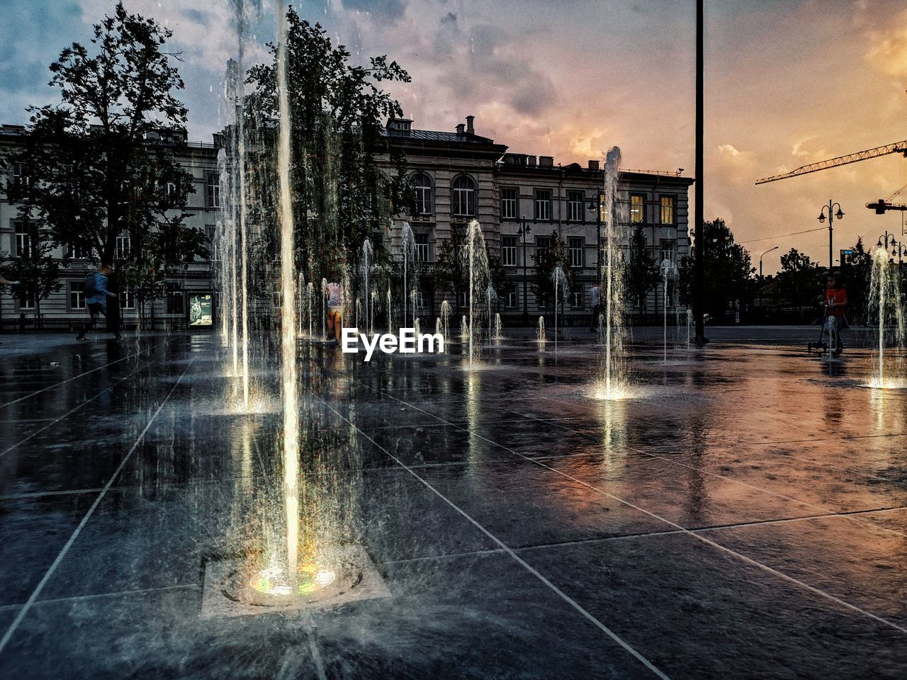 WET STREET BY BUILDINGS AGAINST SKY