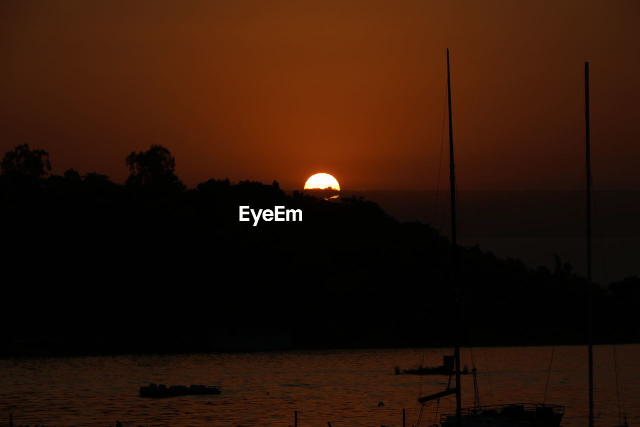 SCENIC VIEW OF SILHOUETTE MOUNTAINS AGAINST ORANGE SKY