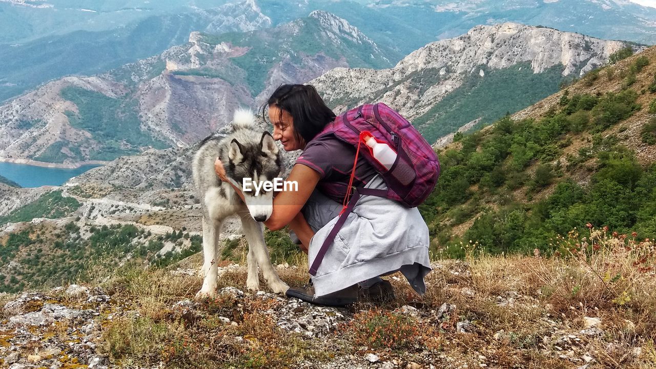 Backpacker with dog on mountain